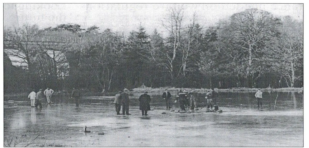 Black-and-white photograph of people curling on the frozen pond, with trees behind