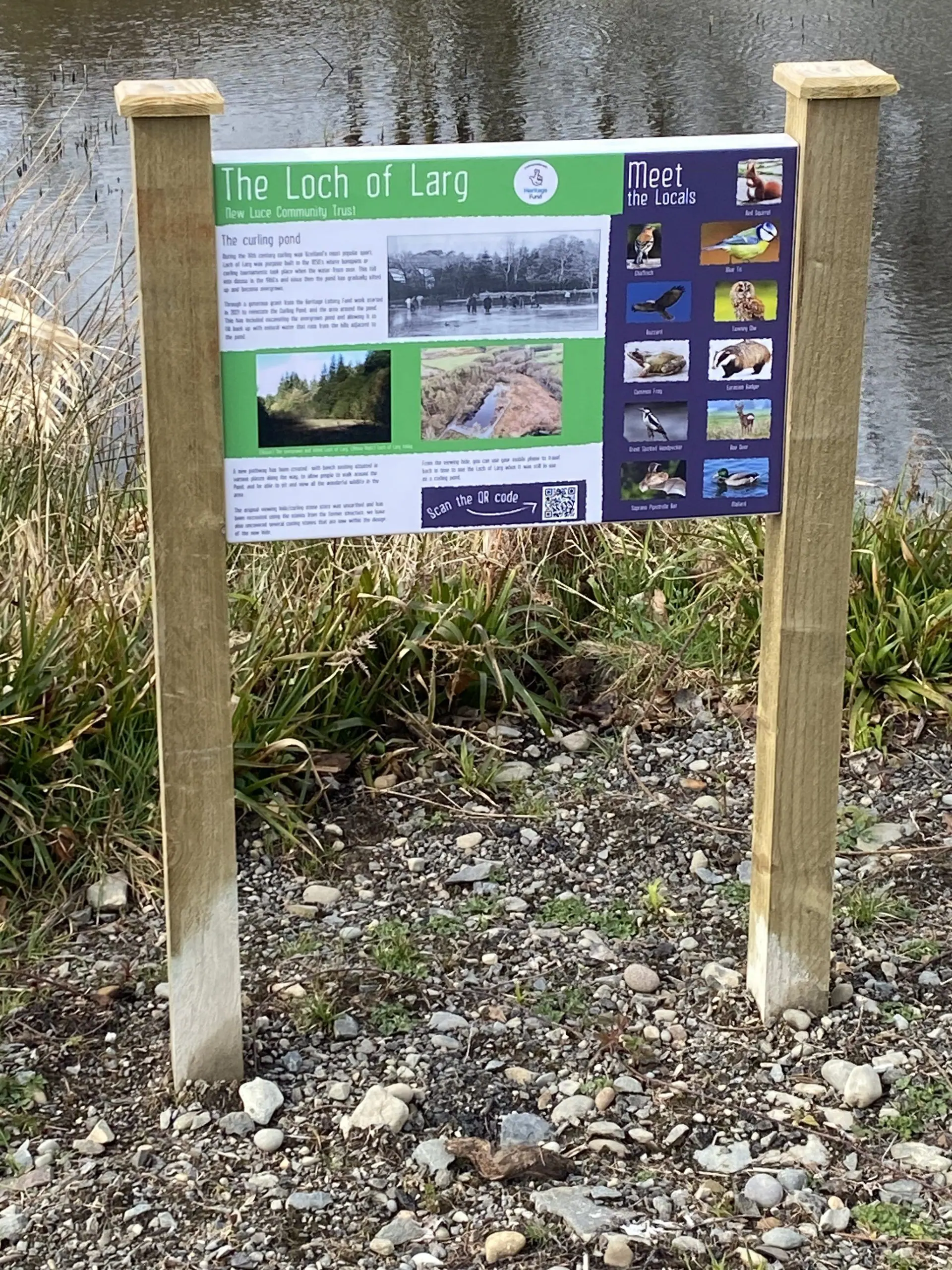 The Loch of Larg Curling Pond interpretation board on two wooden posts beside the path